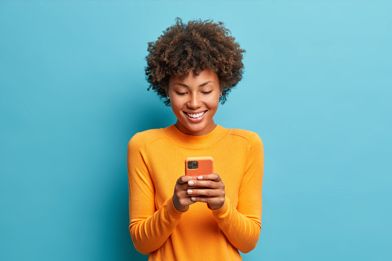 Side view of beautiful woman using her phone indoors.