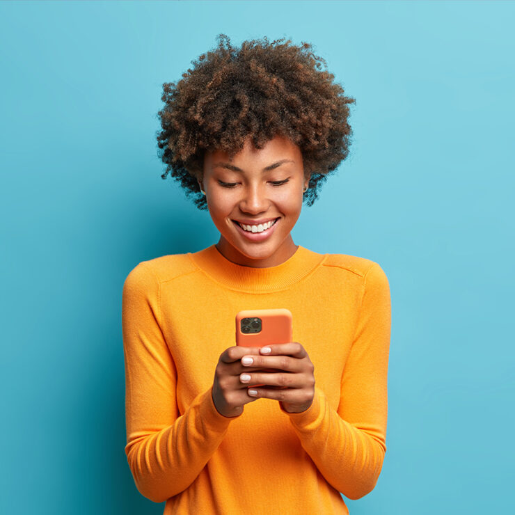 Side view of beautiful woman using her phone indoors.