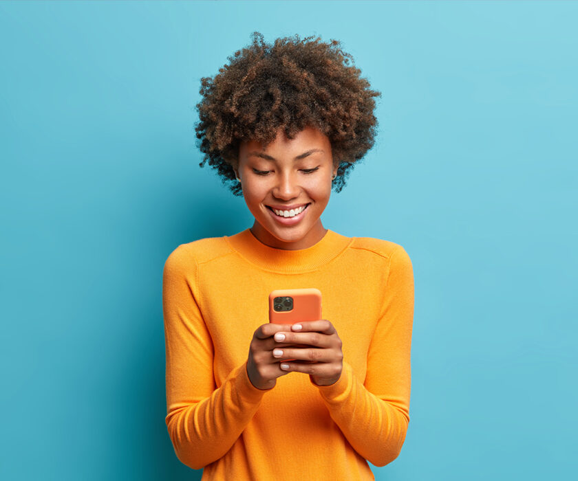 Side view of beautiful woman using her phone indoors.